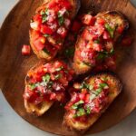 Fresh tomato bruschetta on toasted baguette slices topped with basil, garlic, and olive oil
