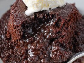 Crockpot lava cake served warm with a molten chocolate center, vanilla ice cream scoop, and powdered sugar dusting