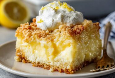 Lemon cream cheese dump cake with golden buttery crumb topping, lemon curd ribbons, and creamy cheesecake pockets