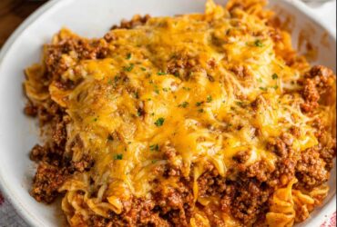 Sloppy joe casserole in a baking dish with golden cheddar topping, biscuit crust, and seasoned ground beef filling