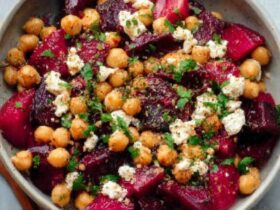 Chickpea beet feta salad in a wooden bowl with vibrant pink-stained chickpeas, crumbled feta, fresh dill, and arugula