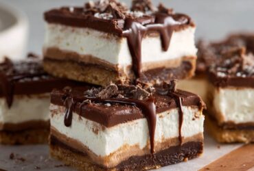 No-bake chocolate cream cheese bars cut into squares with chocolate cookie crust, fluffy cream cheese filling, and chocolate ganache top