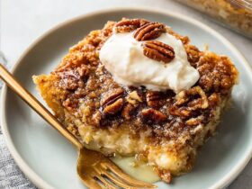 Pecan pie dump cake with golden caramel pecan topping, buttery yellow cake crumb, served warm with vanilla ice cream