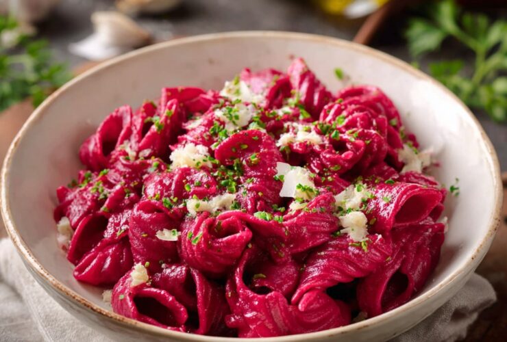 Hot pink beet sauce pasta with creamy roasted beet sauce coating fettuccine, topped with crumbled goat cheese, walnuts, and dill