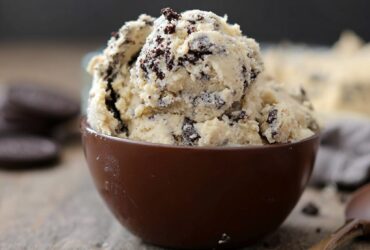 Bowl of edible Oreo cookie dough with chunks of crushed Oreo cookies, brown sugar, butter, vanilla, and chocolate chips, ready to eat by the spoonful