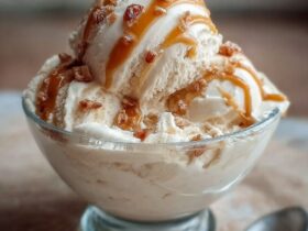 Bowl of high-protein salted caramel cottage cheese ice cream with caramel sauce drizzle, flaky sea salt, and chocolate chips on top