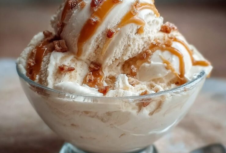 Bowl of high-protein salted caramel cottage cheese ice cream with caramel sauce drizzle, flaky sea salt, and chocolate chips on top
