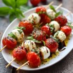 Caprese skewers with cherry tomatoes, fresh mozzarella balls, basil leaves, balsamic glaze drizzle on a wooden serving platter