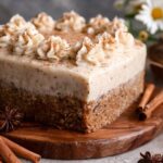 Ultra-moist chai cake with brown butter cream cheese frosting, cinnamon dust, candied ginger, and visible chai-milk-soaked layers