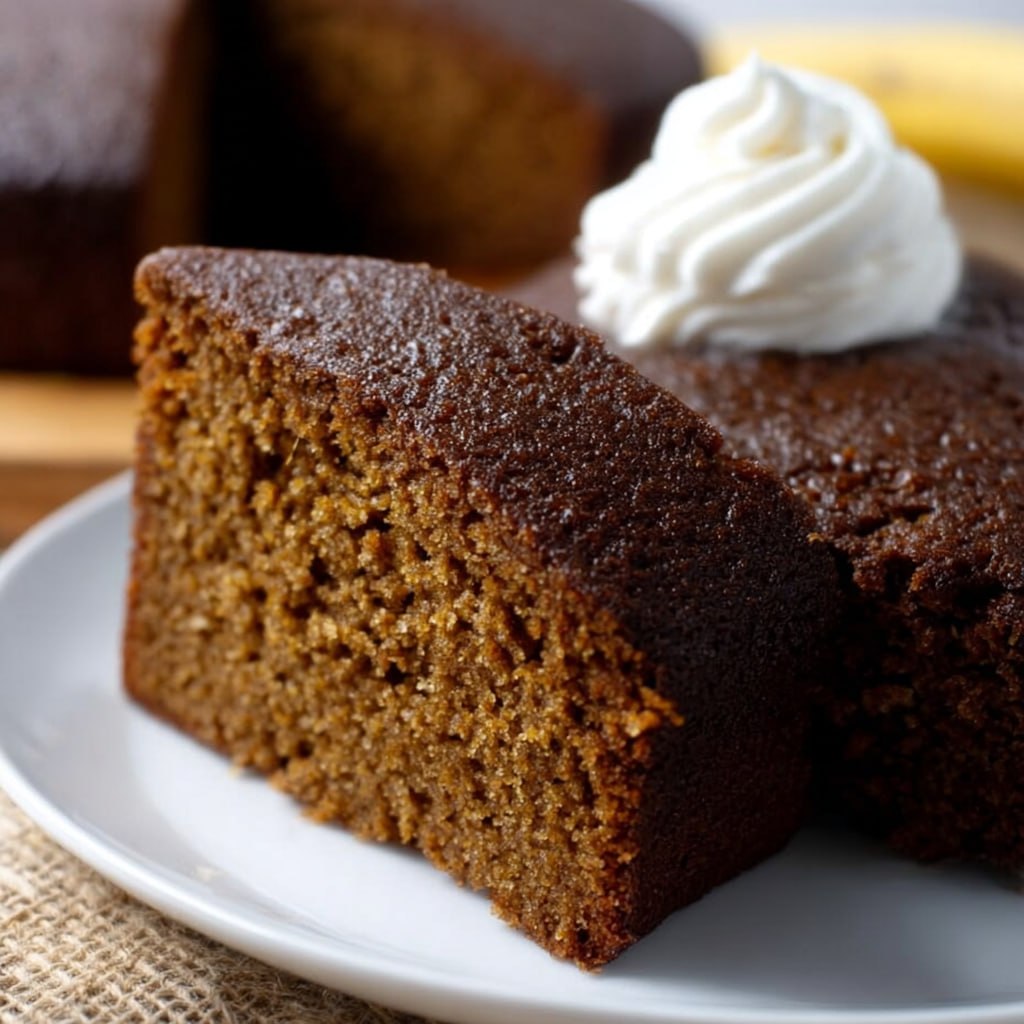 Slice of gingerbread cake showing tender molasses-rich crumb with cinnamon, ginger, cloves, and warm spice notes