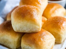 Texas Roadhouse rolls with golden buttery tops, sweet brioche-like interior, served with cinnamon honey butter spread on the side