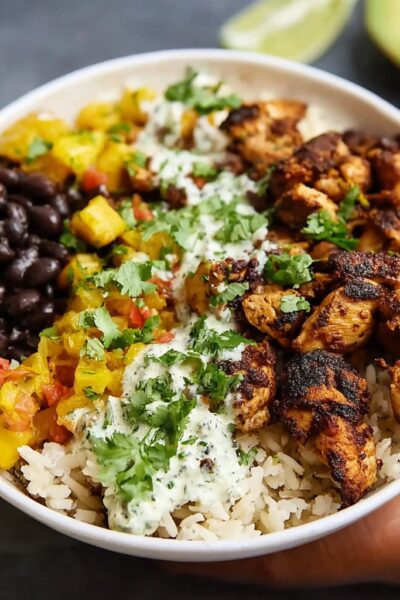 Cuban chicken rice bowl with mojo-marinated chicken thighs over cilantro-lime rice with seasoned black beans, plantains, and avocado