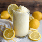 Chick-fil-A frosted lemonade copycat in a tall glass with thick creamy texture, lemon slice on the rim, pale yellow color, whipped cream on top