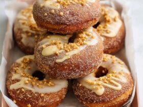 Cinnamon sugar donuts on a wooden plate showing golden baked donuts coated in cinnamon sugar, soft cake-style texture, perfect ring shape