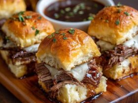 Beef brisket sliders on a wooden board, soft golden Hawaiian rolls split open and stuffed with juicy shredded smoked brisket, glossy BBQ sauce, creamy coleslaw with shredded cabbage and carrot, melted cheese, sesame seed buns topped with butter glaze