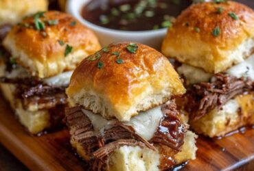 Beef brisket sliders on a wooden board, soft golden Hawaiian rolls split open and stuffed with juicy shredded smoked brisket, glossy BBQ sauce, creamy coleslaw with shredded cabbage and carrot, melted cheese, sesame seed buns topped with butter glaze