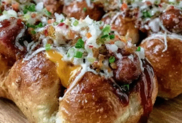 Cheesy hot dog pull apart bread on a wooden board, golden-brown round bread with melted mozzarella strands stretching between buns, sliced hot dogs visible in each bun, garlic butter glaze, parsley flecks, ketchup and mustard on the side