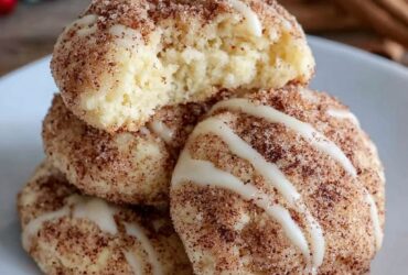 Soft cinnamon sugar cream cheese cookies stacked on a marble surface, crackled cinnamon-sugar tops, pillowy soft centers visible in a broken cookie, warm afternoon light