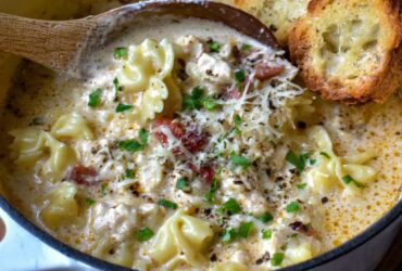 Creamy Italian ground chicken soup in a white bowl, white beans, wilted spinach, ground chicken, glossy parmesan-cream broth, crusty bread on the side, warm morning light