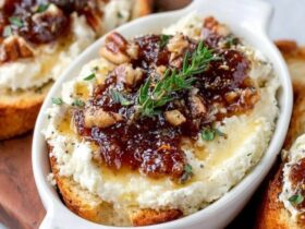 Goat cheese toasts with jam arranged on a wooden board, golden crispy baguette crostini topped with creamy white goat cheese, jewel-toned red fig jam dollops, fresh thyme sprigs, honey drizzle, served with white wine
