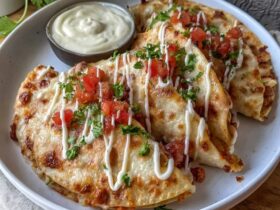 Cheesy chicken quesadillas cut into triangles on a wooden board, crispy golden tortillas with melted cheese oozing out the edges, seasoned chicken visible, served with sour cream, salsa, guacamole on the side