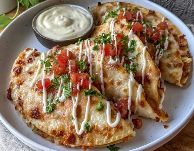 Cheesy chicken quesadillas cut into triangles on a wooden board, crispy golden tortillas with melted cheese oozing out the edges, seasoned chicken visible, served with sour cream, salsa, guacamole on the side