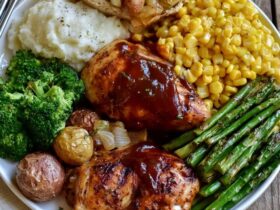 Grilled chicken dinner plate, juicy grill-marked chicken breast with roasted potatoes, grilled vegetables and a lemon wedge, garnished with fresh herbs