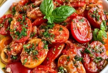 Tomato basil salad on a platter, juicy ripe tomato wedges and cherry tomatoes with fresh mozzarella, torn basil leaves, drizzled with balsamic glaze and olive oil