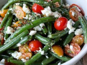 Green bean tomato salad on a platter, crisp-tender blanched green beans tossed with halved cherry tomatoes, crumbled feta, red onion and a lemon vinaigrette, fresh herbs on top