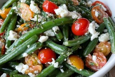 Green bean tomato salad on a platter, crisp-tender blanched green beans tossed with halved cherry tomatoes, crumbled feta, red onion and a lemon vinaigrette, fresh herbs on top