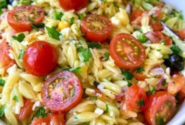 Orzo pasta salad in a bowl, tender orzo with cherry tomatoes, cucumber, red onion, kalamata olives, feta and fresh herbs in a lemon dressing