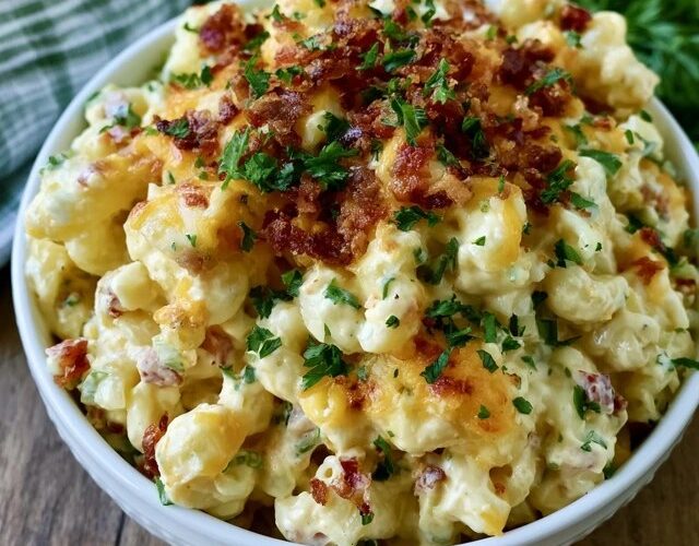 Cheesy bacon ranch pasta salad in a big bowl, rotini coated in creamy ranch dressing with crispy bacon bits, cubed cheddar, cherry tomatoes and chopped green onion on top