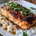 Teriyaki salmon with rice in a bowl, glossy glazed salmon fillet with caramelized edges over white rice with sesame seeds, sliced green onion and steamed broccoli