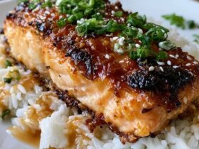 Teriyaki salmon with rice in a bowl, glossy glazed salmon fillet with caramelized edges over white rice with sesame seeds, sliced green onion and steamed broccoli